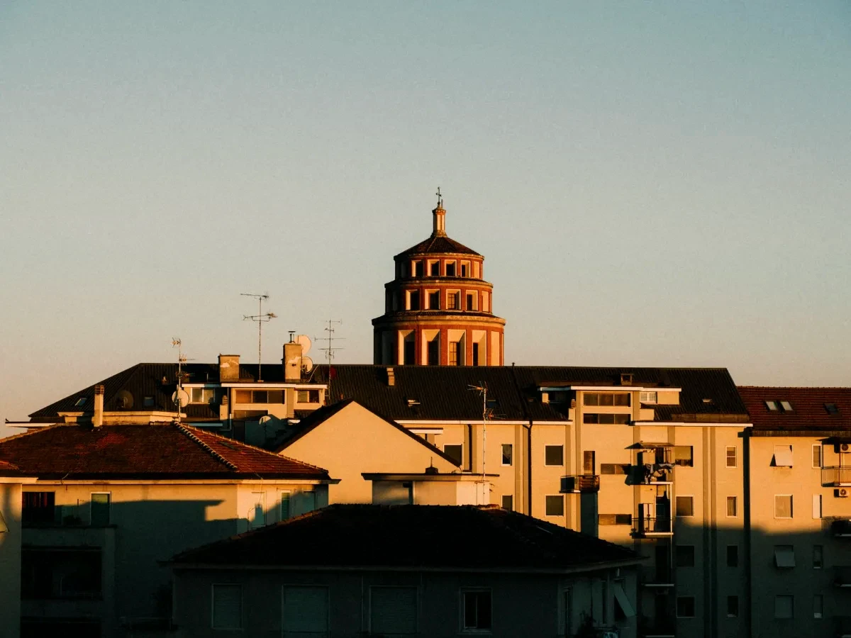 Golden hour light on residential buildings with a dome in Milan, Italy.