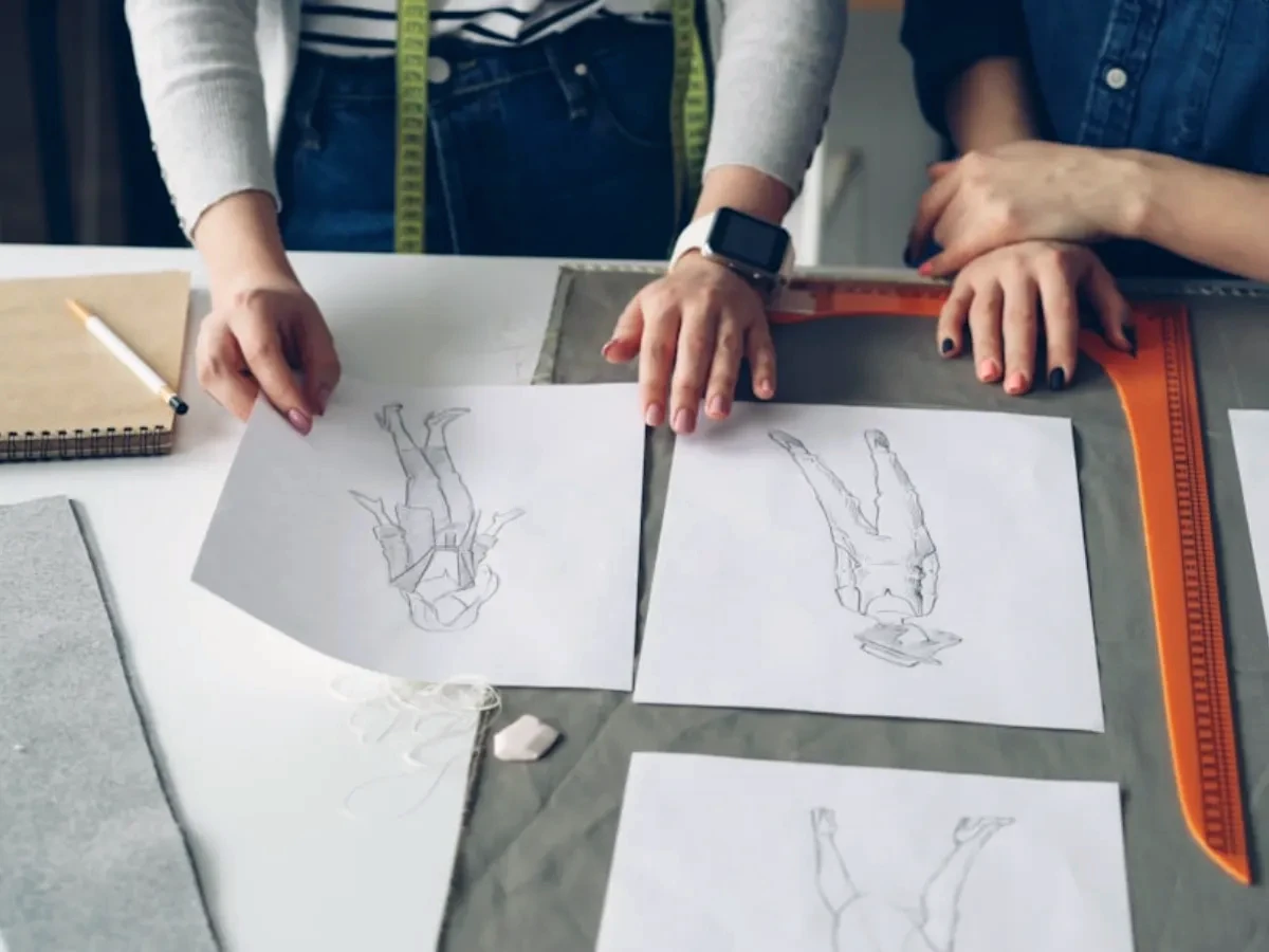 Designers look at sketches and fabrics.