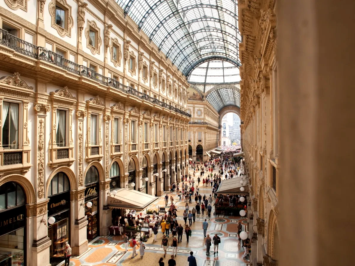 Interior view of Galleria Vittorio Emanuele II in Milan, showcasing its stunning architecture and bustling crowds.